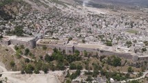 Aerial Orbiting view over Gjirokaster Castle Historic Albanian Landmark with cityscape in background