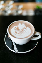 a heart shape in creamer in a coffee cup 