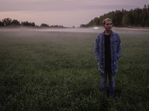 a man standing in a foggy field in Sweden 