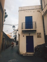 pedestrians walking in an alley between buildings 