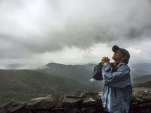 woman praying on a mountain top 