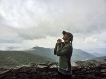 woman praying on a mountaintop 