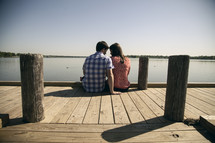 Couple sitting on a pier.