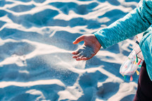 a child playing with sand on a beach 