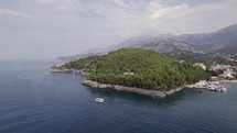 Aerial of boat sailing the Albanian Riviera in Himare Ionian Sea Coast 