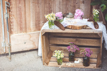 wood crate filled with flowers in vases 