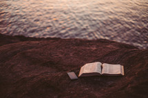 open Bible at the edge of a waterway