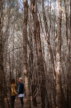 couple holding hands in a forest 