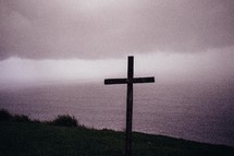 Silhouette of a wooden cross at the ocean.