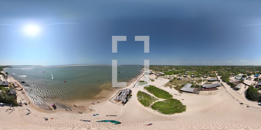 360 aerial photo taken with drone of kite surfing next to beachside restaurants in Lençóis Maranhenses in the afternoon on the northern coast of Brazil