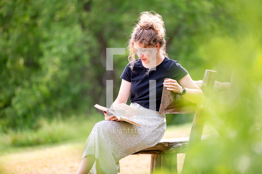 Woman sitting alone reading Bible