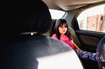 a child in a booster seat in the backseat of a car 