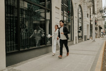 a couple walking through a city holding hands 