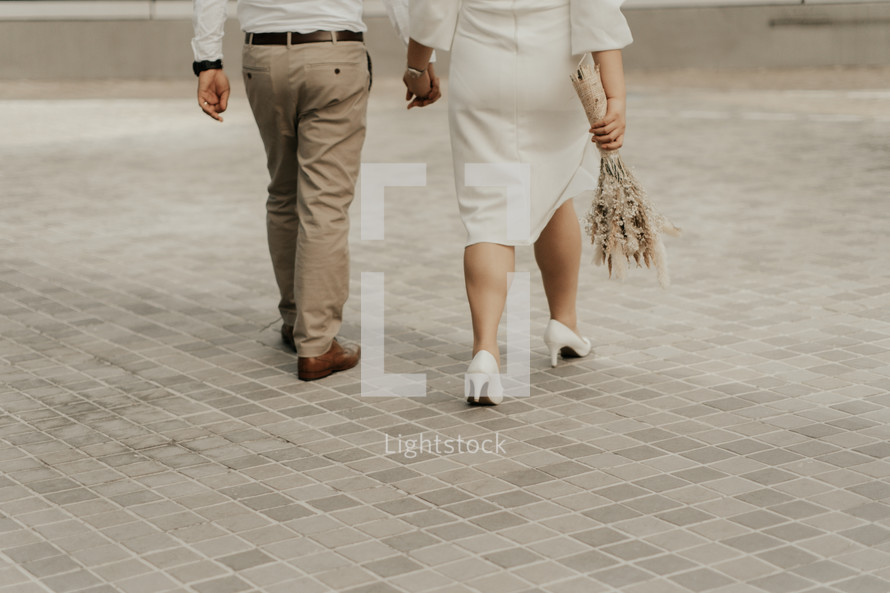 a couple walking holding hands 