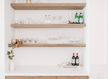 wine glasses and bottles on floating shelves 
