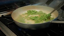 Chef Cooking Green Tagliatelle Pasta Italian Food In The Pan Of A Restaurant