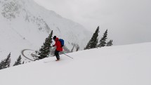 Male skiing fresh powder snow down mountain face 