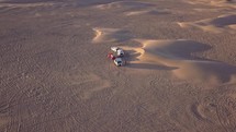 Aerial of RV campers parked near sand dunes in the desert