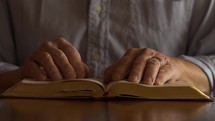 Close up of a man studying his Bible and praying