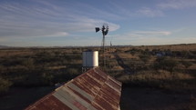 Aerial pullback of a ranch windmill and an old barn
