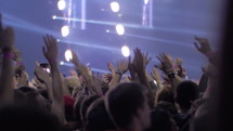 Slow motion shot of unidentified man waving hand to music rhythm at the concert