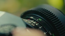 Close up of old retro vintage film camera while a female hand turning the focus wheel 