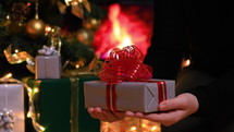 placing a Christmas gift under the Christmas tree 