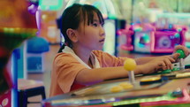 Little girl is playing games at the amusement park
