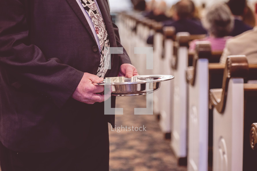men ushers holding offering plates during a Sunday morning worship service 