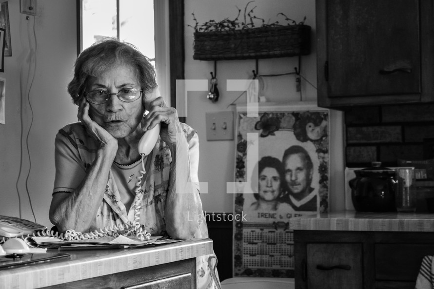 elderly woman talking on a telephone 