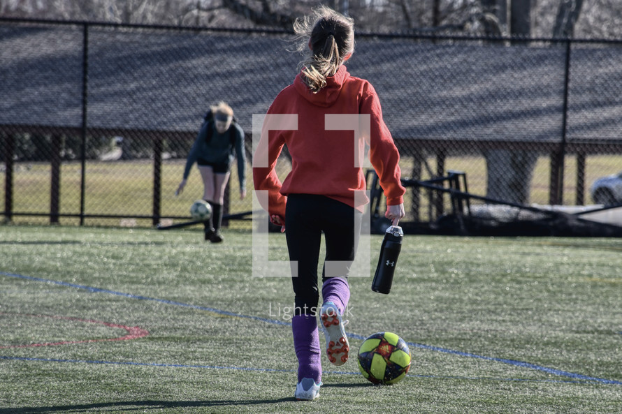 a girl running with a soccer ball 