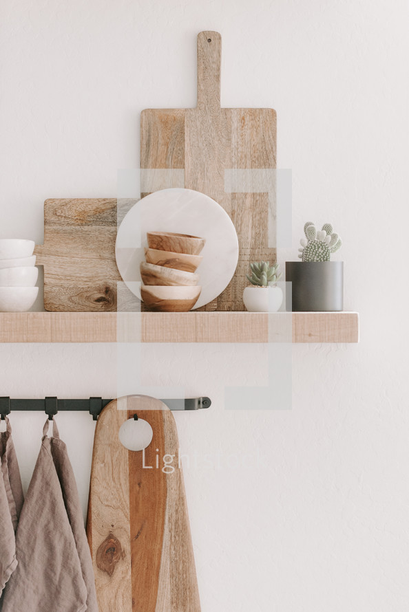 wooden cutting boards on a floating shelf 