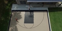 aerial shot of teen boy playing basketball outdoors