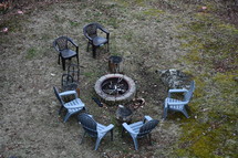 empty chairs around a fire pit 