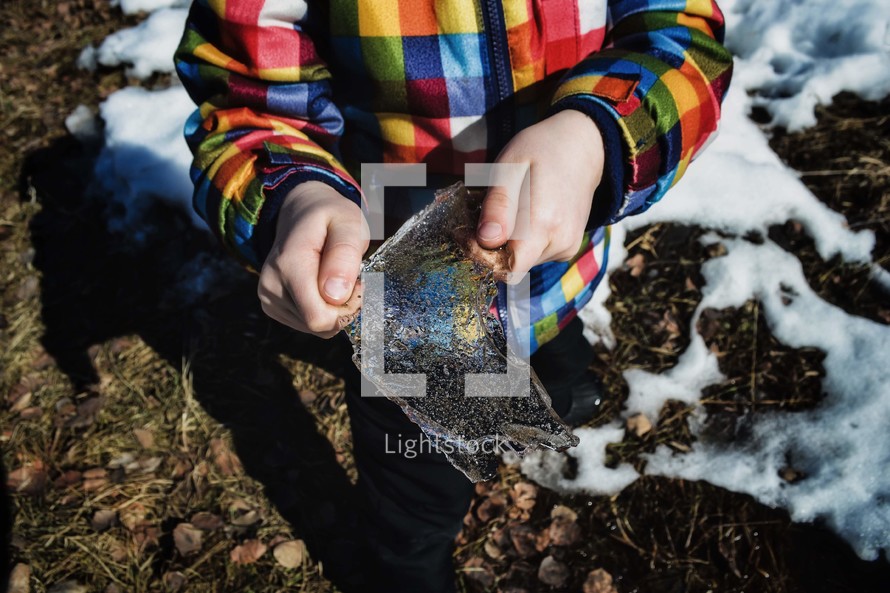 child holding a chunk of ice 