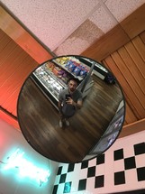 reflection of a man in a mirror in a convenience store 