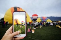 taking a picture of a hot air balloon festival with a cellphone 