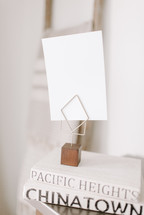 envelope on a photo holder on a stack of books 