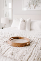wooden tray on a made bed 