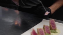 Chef plating tuna fish for hotel restaurant diners
