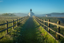 green path leading to a rural white church 