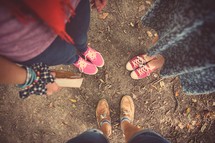 feet of women in a prayer circle 