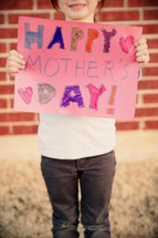 A photo of a kid making a Mother's Day Card