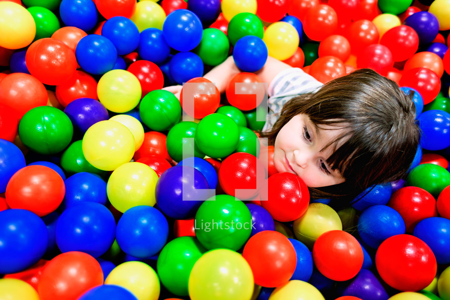 girl child playing in a ball pit 