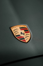 Porsche logo badge on a grey vehicle, German car manufacturer 