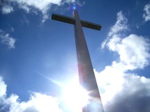 The Reach of the Cross from Heaven to Earth - A Powerful photograph by Artist Rick Short of the Cross reaching above the clouds and sunset reaching from the earth to the Heavens with a sun flare in the background. 