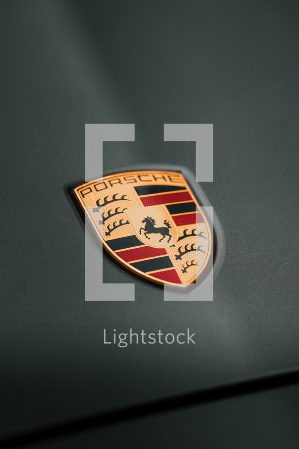 Porsche logo badge on a grey vehicle, German car manufacturer 