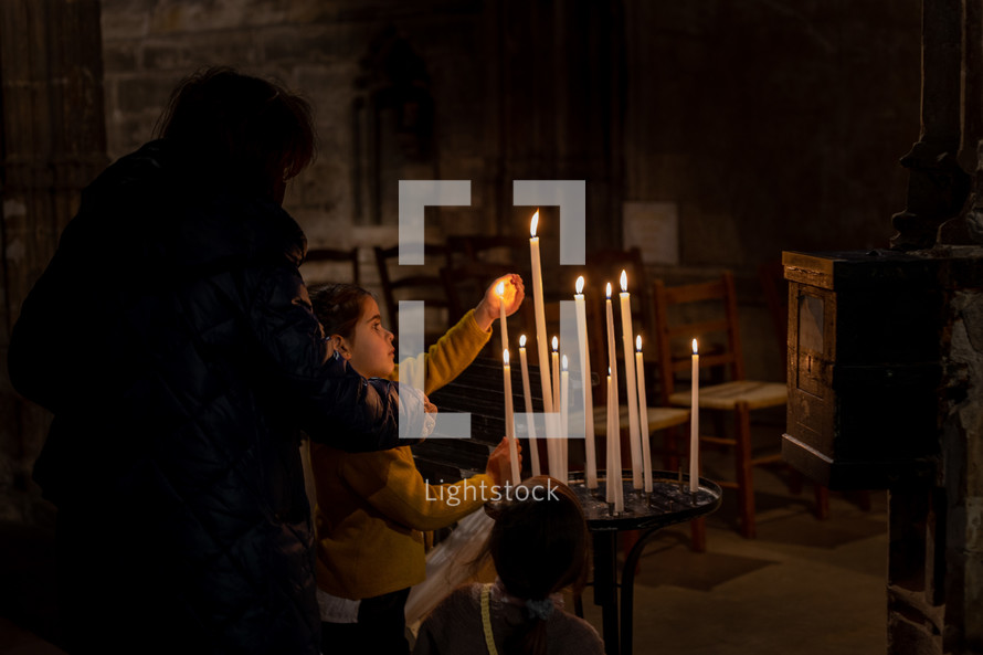 children lighting candles at church 