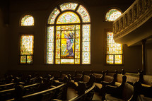 A church sanctuary with decorative stained glass windows.
