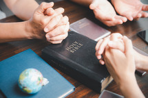 People praying for the world with a BIble